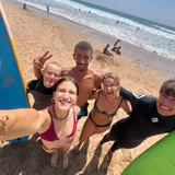 Group of four young surfers with coach Simo on the Agadir coast